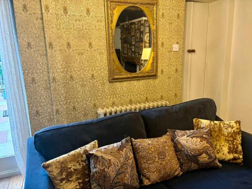 a blue couch with pillows in front of a mirror at Liberty House in Ashbourne