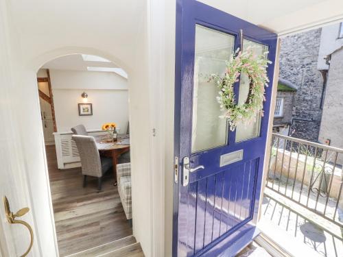 une porte bleue menant à un balcon avec une table. dans l'établissement The Landings, à Kirkby Lonsdale
