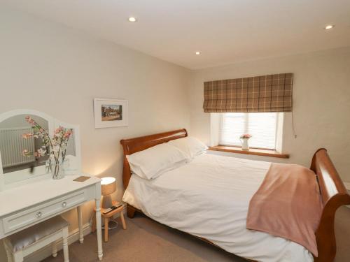 une chambre avec un lit, un bureau et une fenêtre dans l'établissement The Landings, à Kirkby Lonsdale