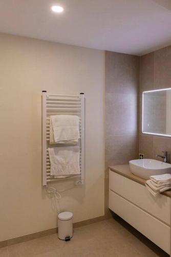a bathroom with a sink and a toilet and towels at Casa Galvão Arcos de Valdevez in Arcos de Valdevez