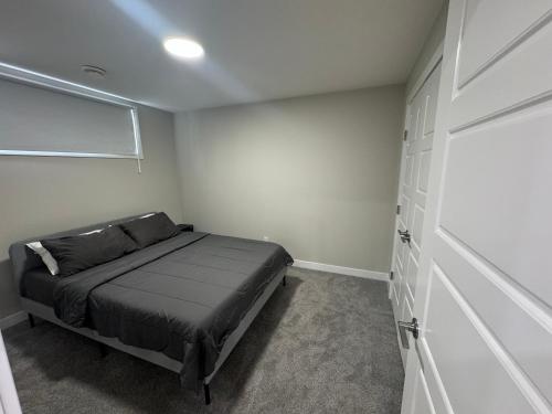 ein kleines Schlafzimmer mit einem Bett und einem Schrank in der Unterkunft Cozy 1 bedroom basement apartment in Airdrie