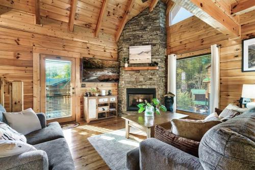 a living room with a stone fireplace in a cabin at Groot's Place - 5 min to main parkway!! in Pigeon Forge