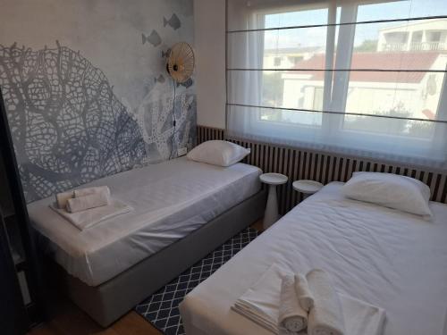 a small room with two beds and a window at Apartman Plesa in Povljana