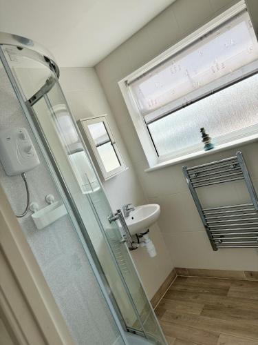 a bathroom with a glass shower and a sink at Tranquility at Sandown Bay in Sandown