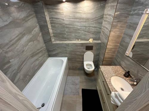 ein Badezimmer mit Badewanne, Toilette und Waschbecken in der Unterkunft AIRPORT HOTEL APARTAMENTS & TAXI ViP in Chişinău