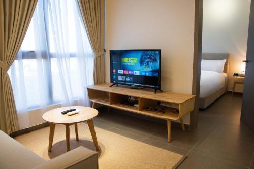 a living room with a television and a bed at 5 Mossaz Muji 2 room at Empire City by Light House in Petaling Jaya