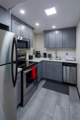 a kitchen with stainless steel appliances and blue cabinets at West Seattle 2BR Easy Access to Stadiums & Downtown in Seattle