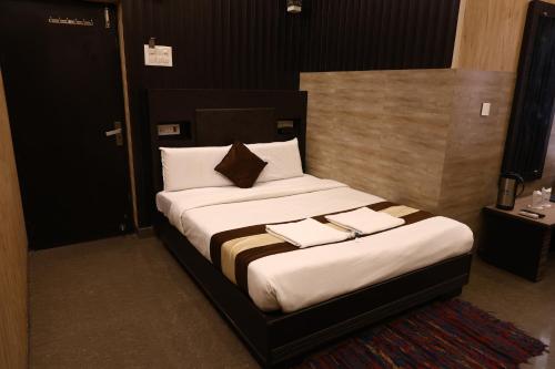 a bedroom with a bed with two towels on it at Hotel Pardesi,Har ki pauri Road Haridwar in Haridwār
