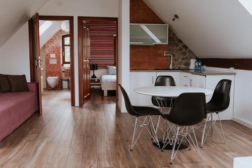 a kitchen and a living room with a table and chairs at Folwark Pszczew in Pszczew