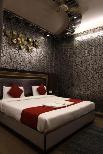 a bedroom with a large bed with red pillows at Hotel Pardesi,Har ki pauri Road Haridwar in Haridwār