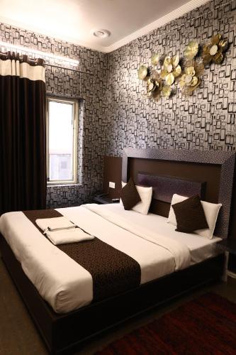 a bedroom with a large bed and a window at Hotel Pardesi,Har ki pauri Road Haridwar in Haridwār