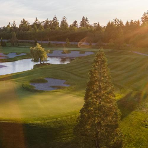 an aerial view of a golf course with a pond at Naturally Pacific Resort in Campbell River
