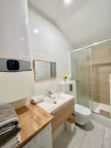 une salle de bain blanche avec un lavabo et des toilettes dans l'établissement Chic 3 pièces Massy centre proche Paris, à Massy