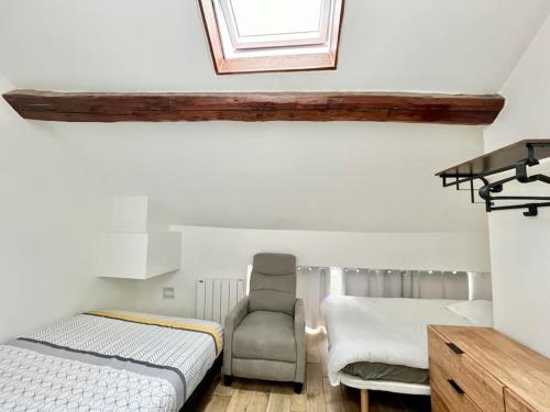 une chambre avec deux lits et une chaise et une fenêtre dans l'établissement Chic 3 pièces Massy centre proche Paris, à Massy