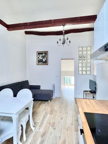 un salon avec une table blanche et un canapé dans l'établissement Chic 3 pièces Massy centre proche Paris, à Massy