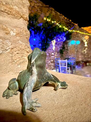 a statue of a frog sitting on a wall at Casa Rural Italuna in Jarque de la Val