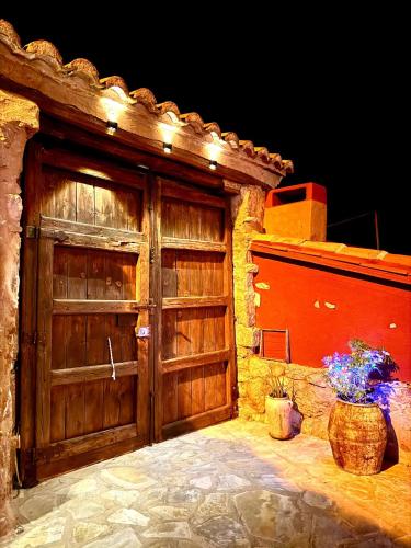 a wooden garage with a large wooden door with flowers at Casa Rural Italuna in Jarque de la Val