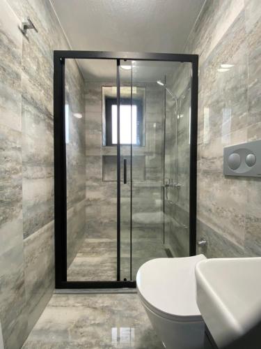 a bathroom with a shower and a toilet and a sink at Luxury Stone House With Turkish Hamam, Sauna, İndoor and Outdoor Pool in Fethiye in Mugla