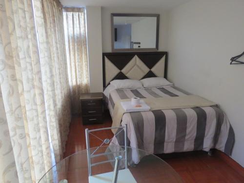 a bedroom with a bed with a mirror and a glass table at Hospedaje El Rinconcito in Jauja