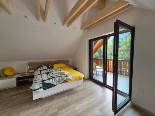 a bedroom with a bed and a balcony at Hiša Oblak in Gozd Martuljek