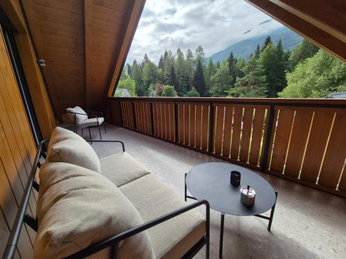 a balcony with a couch and a table and a large window at Hiša Oblak in Gozd Martuljek