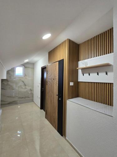 a room with a hallway with a door and a shelf at Hotel Mažijanik in Nikšić