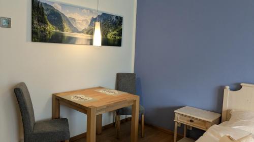 a room with a table and two chairs and a bed at Ferienwohnung Alpenglück in Bolsterlang Sommerbergbahn kostenlos in Bolsterlang