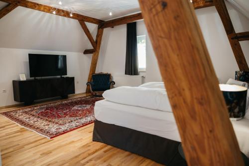 a bedroom with a bed and a flat screen tv at Georgi Schloss - Boutique Hotel in Ehrenhausen