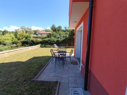 a patio with a table and chairs next to a building at Apartma LANA in Koper