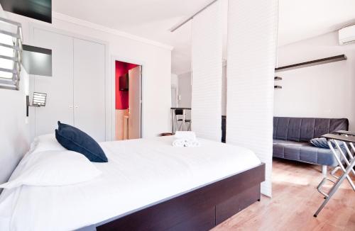 - une chambre avec un grand lit blanc et un canapé dans l'établissement Plaza Mayor II, à Madrid