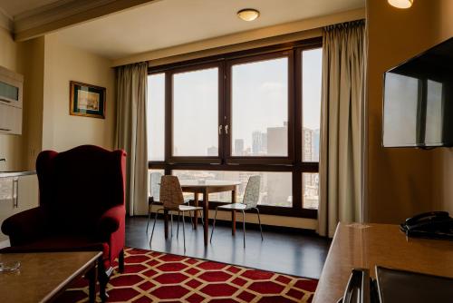 a living room with a table and a large window at Om Kolthoom Hotel in Cairo