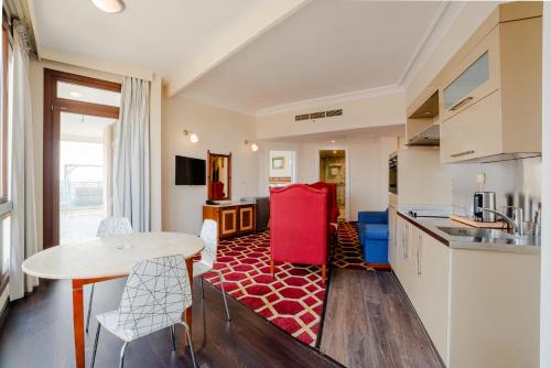 a kitchen and living room with a table and chairs at Om Kolthoom Hotel in Cairo