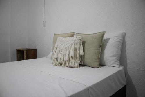 a white bed with white sheets and pillows at The Boat House Cancun in Cancún