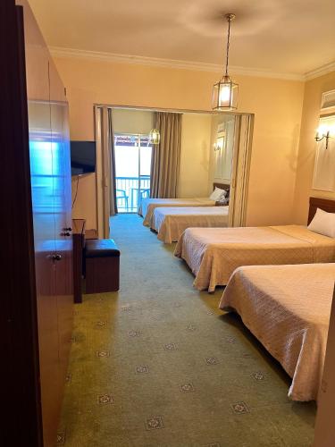 a hotel room with three beds and a window at Le Crillon in Broummana