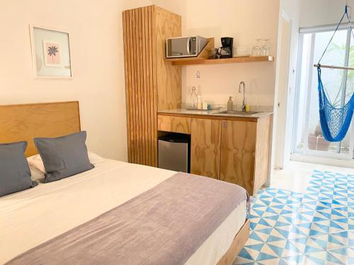 a bedroom with a bed and a kitchen with a sink at Studios Downtown Cancun in Cancún