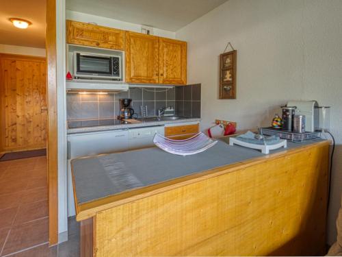 - une cuisine avec un comptoir et un four micro-ondes dans l'établissement Appartement rénové à Morillon avec terrasse, proche du lac et arrêt navette - FR-1-642-36, à Morillon