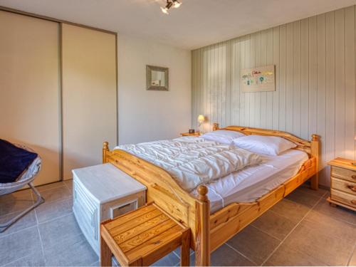 une chambre avec un lit en bois et une chaise dans l'établissement Appartement rénové à Morillon avec terrasse, proche du lac et arrêt navette - FR-1-642-36, à Morillon