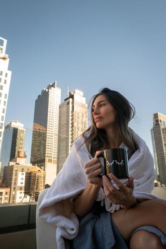 a woman sitting in a towel holding a mug at INNSiDE by Meliá New York Nomad in New York