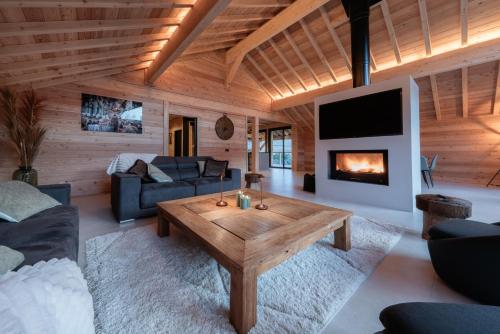 a living room with a table and a fireplace at Chalet luxe & spa, Black Diamond in Briançon
