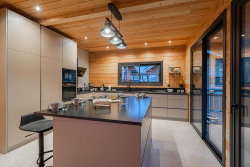a kitchen with a large island in a house at Chalet luxe & spa, Black Diamond in Briançon