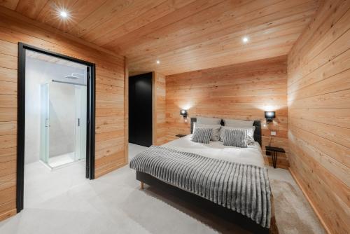 a bedroom with a bed in a wooden wall at Chalet luxe & spa, Black Diamond in Briançon
