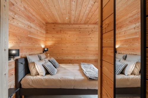 a room with a bed in a wooden cabin at Chalet luxe & spa, Black Diamond in Briançon