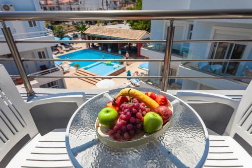 a bowl of fruit on a glass table on a balcony at Economisa Apartments in Ialyssos