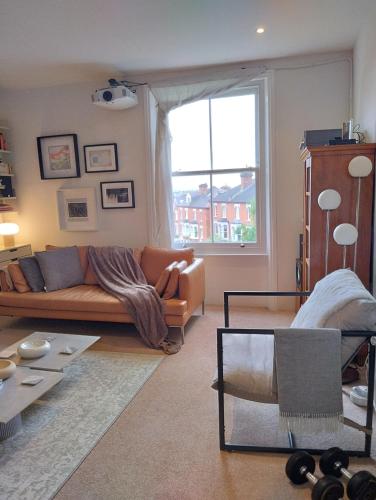 a living room with a couch and a window at Cosy oasis with a view in London