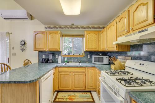 a kitchen with wooden cabinets and a white stove top oven at Private Hot Tub Lakefront Poconos Home! in Pocono Summit