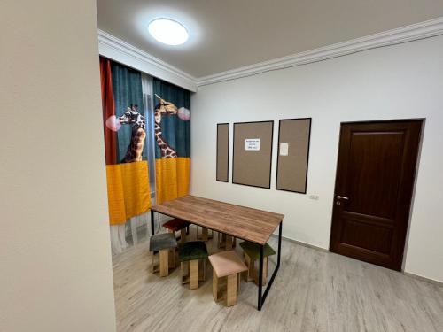 a room with a table and a painting on the wall at Velvet Vouge Hostel in Yerevan