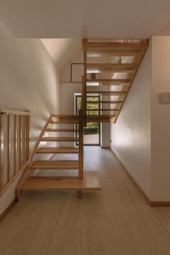 a loft bed with wooden stairs in a room at Rycerki Dom na Szlaku in Rajcza
