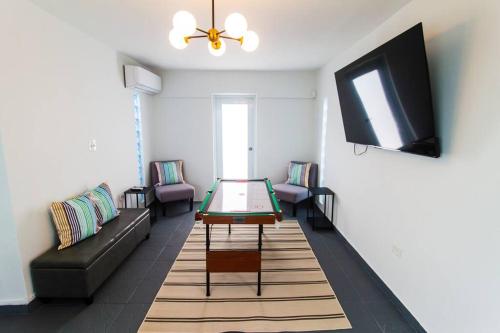 a living room with a couch and a table and a tv at Modern Penthouse in Carolina in Cuatro Caminos