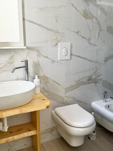 a white bathroom with a sink and a toilet at Il Sentiero in Bari