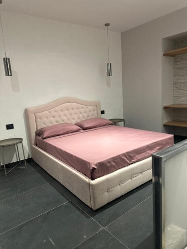 a bedroom with a large bed with pink sheets at Dimora del Centro in Rivarolo Canavese